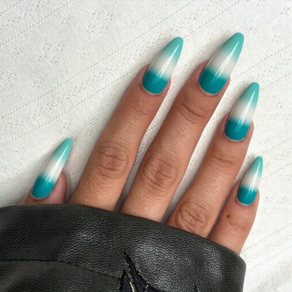 Long stiletto nails in a gradient from teal to white, mimicking the colors of the ocean for a seaside vacation.