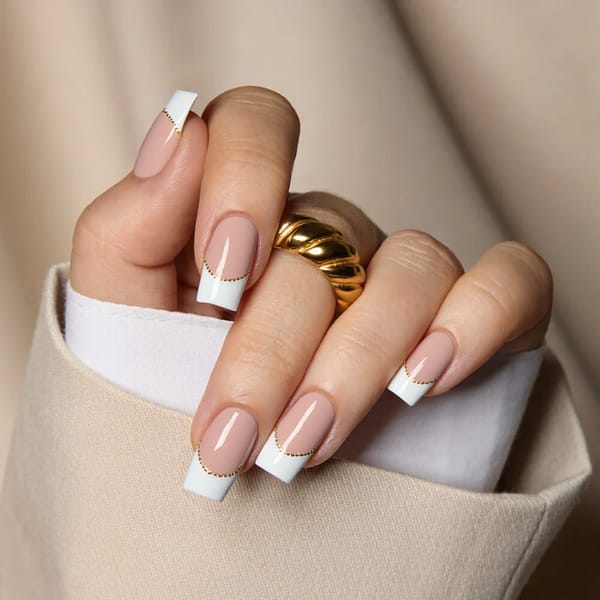 Medium square nails in a classy French manicure with a thin gold line tracing the tips—elegant for engagement photos.