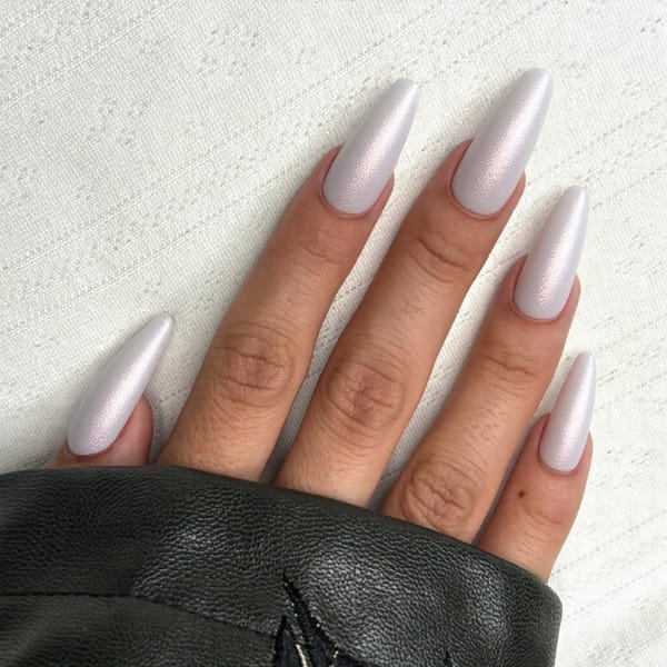 Long stiletto nails in a pearlescent white with subtle pink shimmer, perfect for a classy February event.