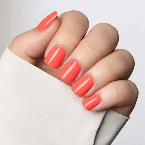 Short square nails in a cheerful coral with a clear gloss topcoat