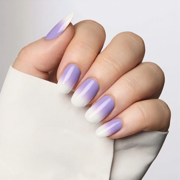 Medium almond nails in a lilac ombre that fades into white at the tips for a dreamy effect.