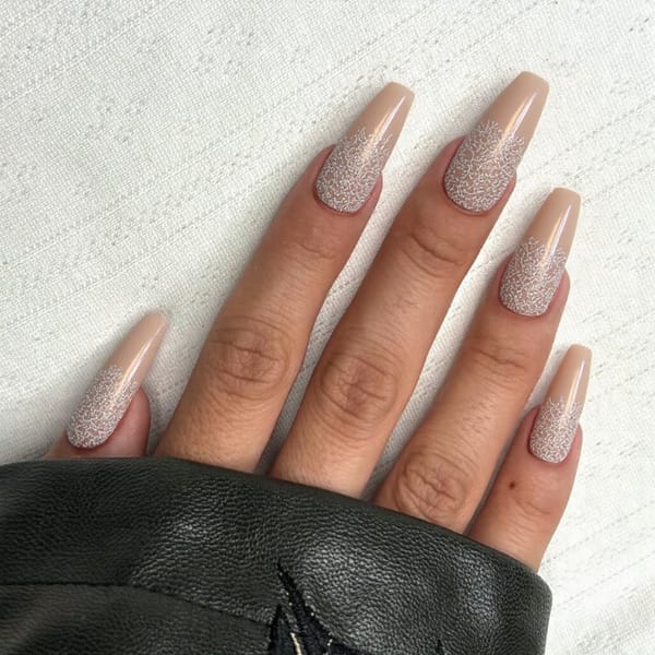 Long stiletto nails in a sheer nude with subtle lace-like detail
