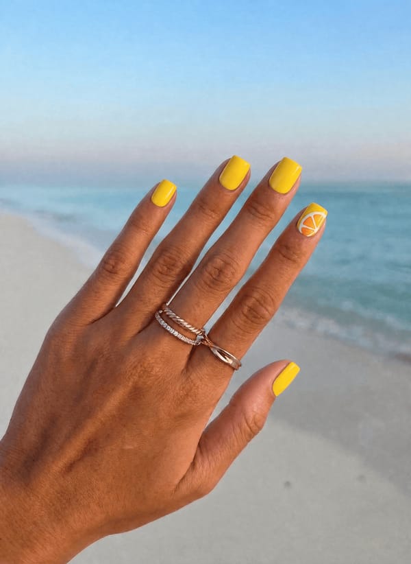 Vibrant lemon-yellow glossy base, short squoval nails, with a hand-painted orange slice motif on the accent nail for a fresh citrusy vibe. Nail shape: square. Nail length: short. Only change the nails visible in the image to match this design. Keep the rest of the image — the hand, skin, background, lighting, and everything else — exactly the same.
