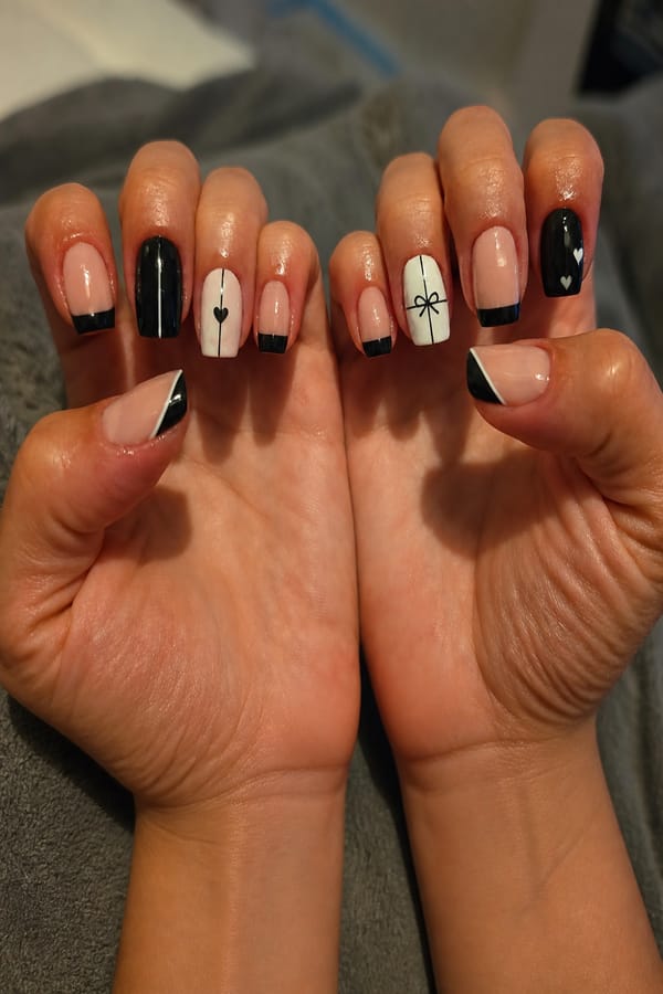 give a cool design for my birthday nails. 30 years old. black, white and nude. simple but elegant. crisp lines. Nail shape: square. Nail length: short. Only change the nails visible in the image to match this design. Keep the rest of the image — the hand, skin, background, lighting, and everything else — exactly the same.