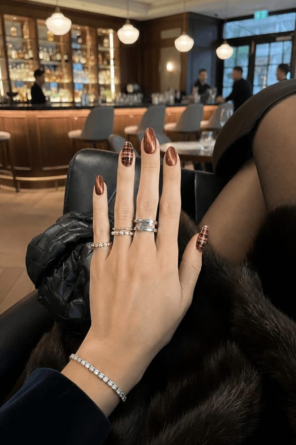 fall,cat eye and plaid Nail shape: almond. Nail length: short. Only change the nails visible in the image to match this design. Keep the rest of the image — the hand, skin, background, lighting, and everything else — exactly the same.