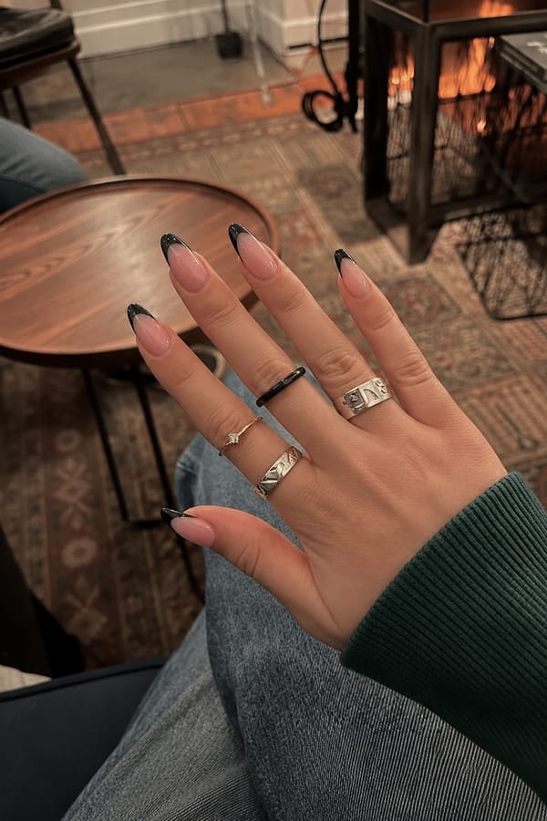 pink and black Nail shape: almond. Nail length: medium. Only change the nails visible in the image to match this design. Keep the rest of the image — the hand, skin, background, lighting, and everything else — exactly the same.