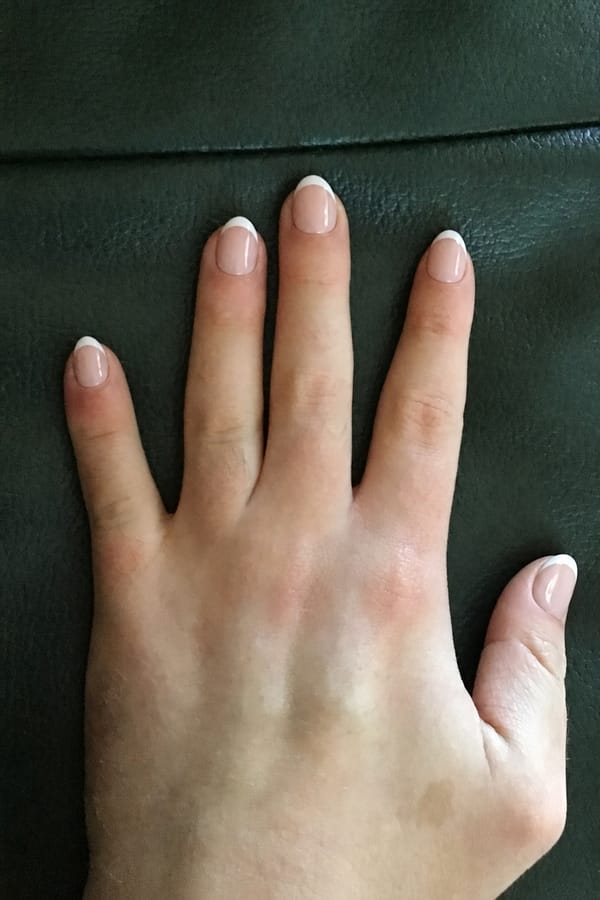 summer French Nail shape: almond. Nail length: short. Only change the nails visible in the image to match this design. Keep the rest of the image — the hand, skin, background, lighting, and everything else — exactly the same.