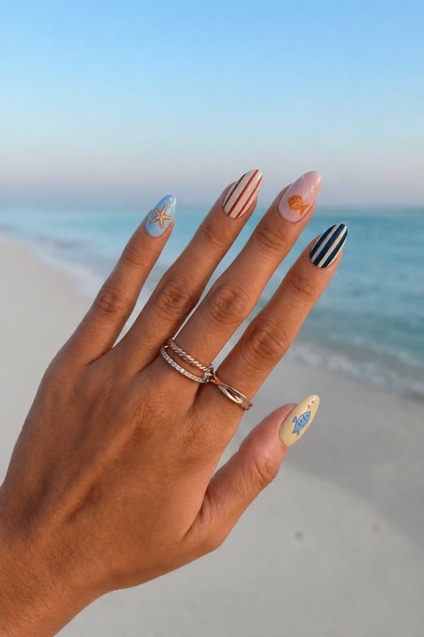 Mixed glossy set, 5 accent nails: Pastel blue base with hand-painted starfish. Nude base with red vertical stripes. Soft pink base with small orange fish illustration. Navy base with beige vertical stripes. Pale yellow base with blue fish illustration. Nail shape: almond. Nail length: short. Only change the nails visible in the image to match this design. Keep the rest of the image — the hand, skin, background, lighting, and everything else — exactly the same.