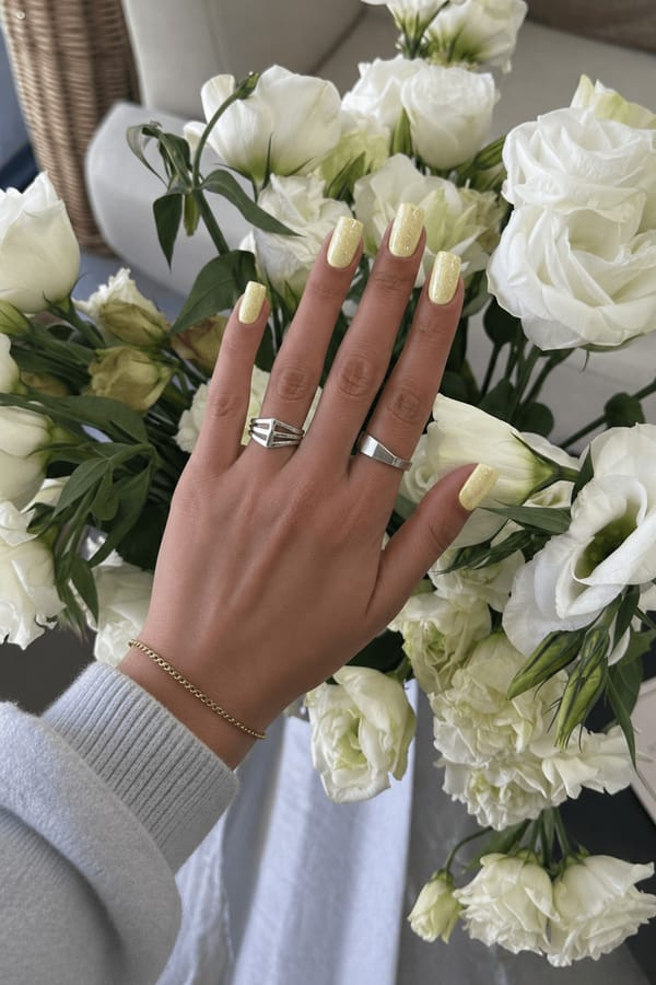Medium square nails in pastel yellow with fine silver glitter