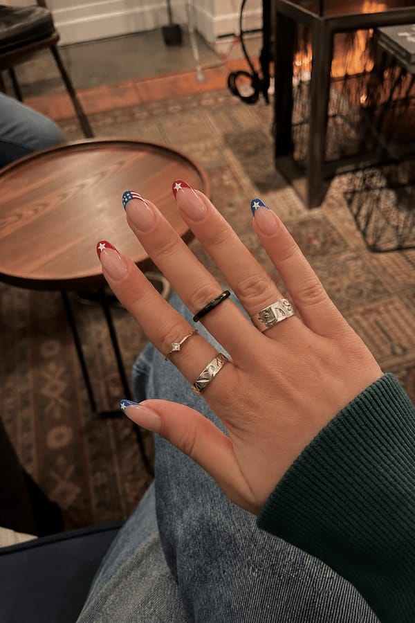 4th of July French Nail shape: almond. Nail length: short. Only change the nails visible in the image to match this design. Keep the rest of the image — the hand, skin, background, lighting, and everything else — exactly the same.