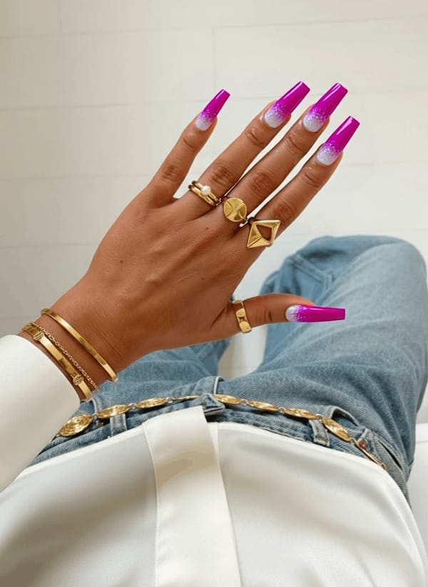 Long almond nails in a fuchsia ombre fading toward a lighter pink