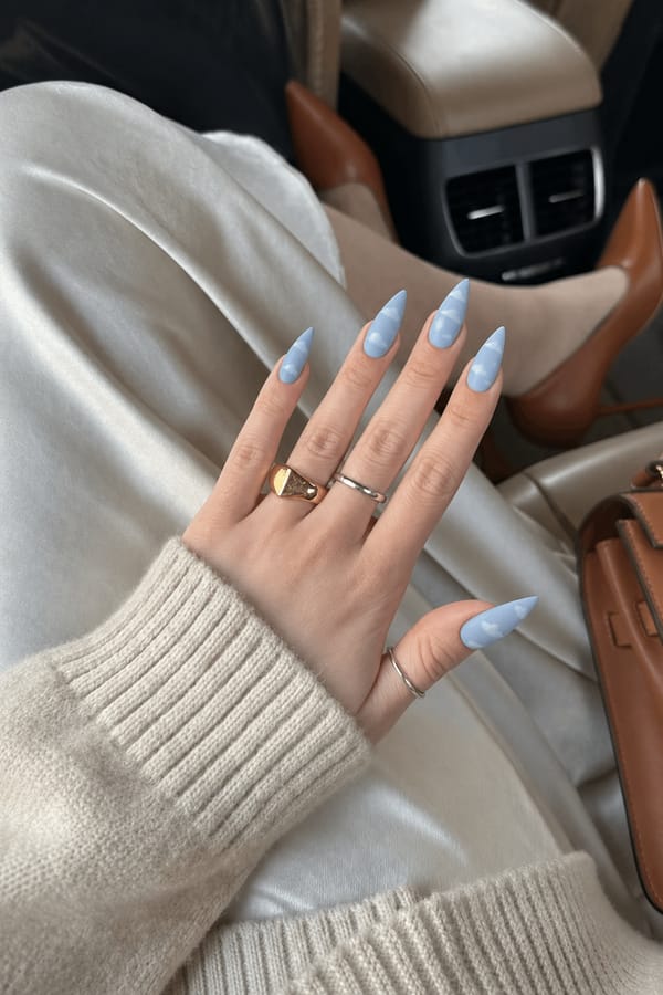 Long stiletto nails in sky blue with matte white cloud patterns
