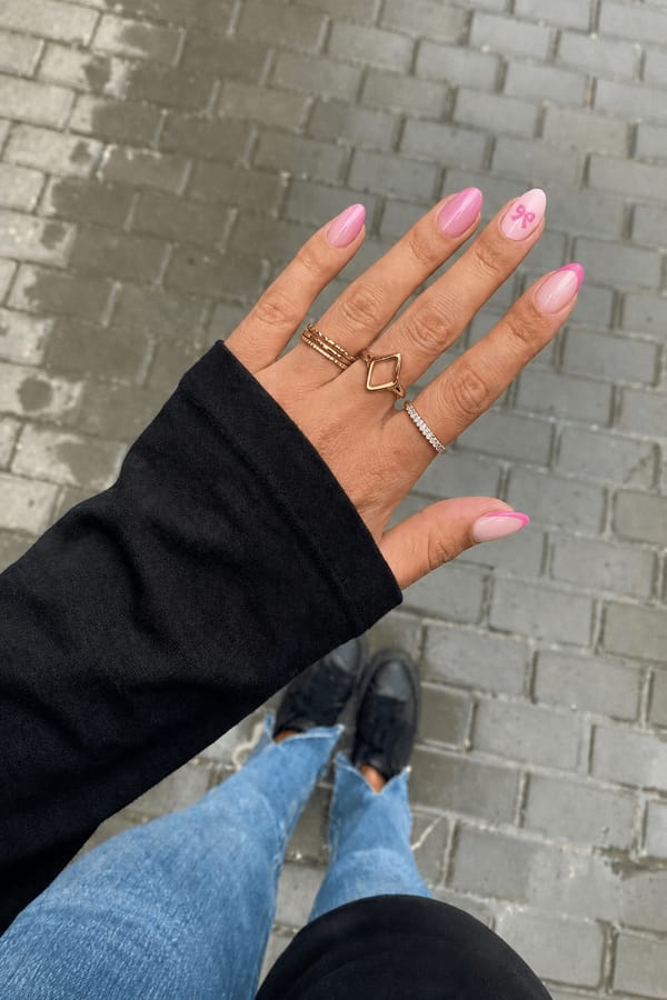 thumb: pink French tip pointer finger: aura effect with light and bright pink middle finger: pink French tip left index finger: bright pink bow facing away from the cuticle￼ with light pink background pinky: pink French tip Nail shape: almond. Nail length: medium. Only change the nails visible in the image to match this design. Keep the rest of the image — the hand, skin, background, lighting, and everything else — exactly the same.