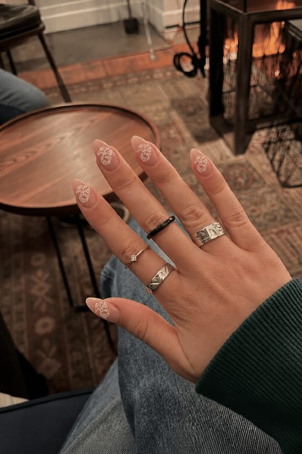 marine corps logo outline Nail shape: almond. Nail length: medium. Only change the nails visible in the image to match this design. Keep the rest of the image — the hand, skin, background, lighting, and everything else — exactly the same.
