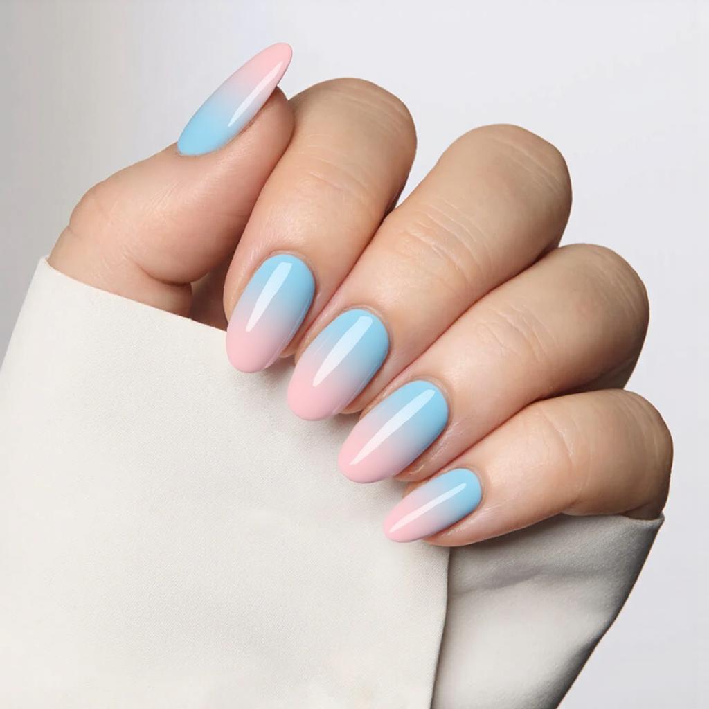 Medium almond nails in a pastel ombre—transitions from light blue at the cuticle to pale pink at the tip.