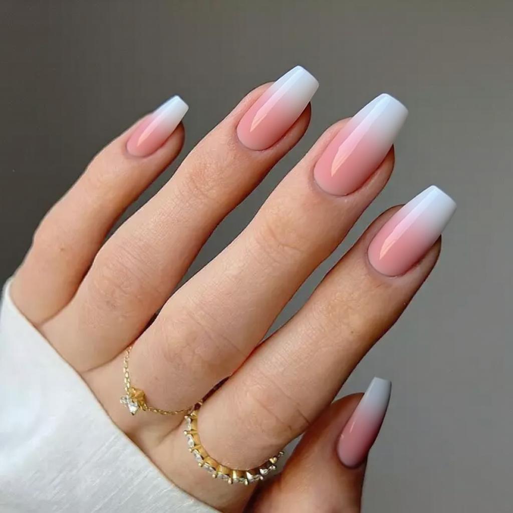 Medium stiletto nails in a French ombre style, blending pink into white seamlessly on each nail.