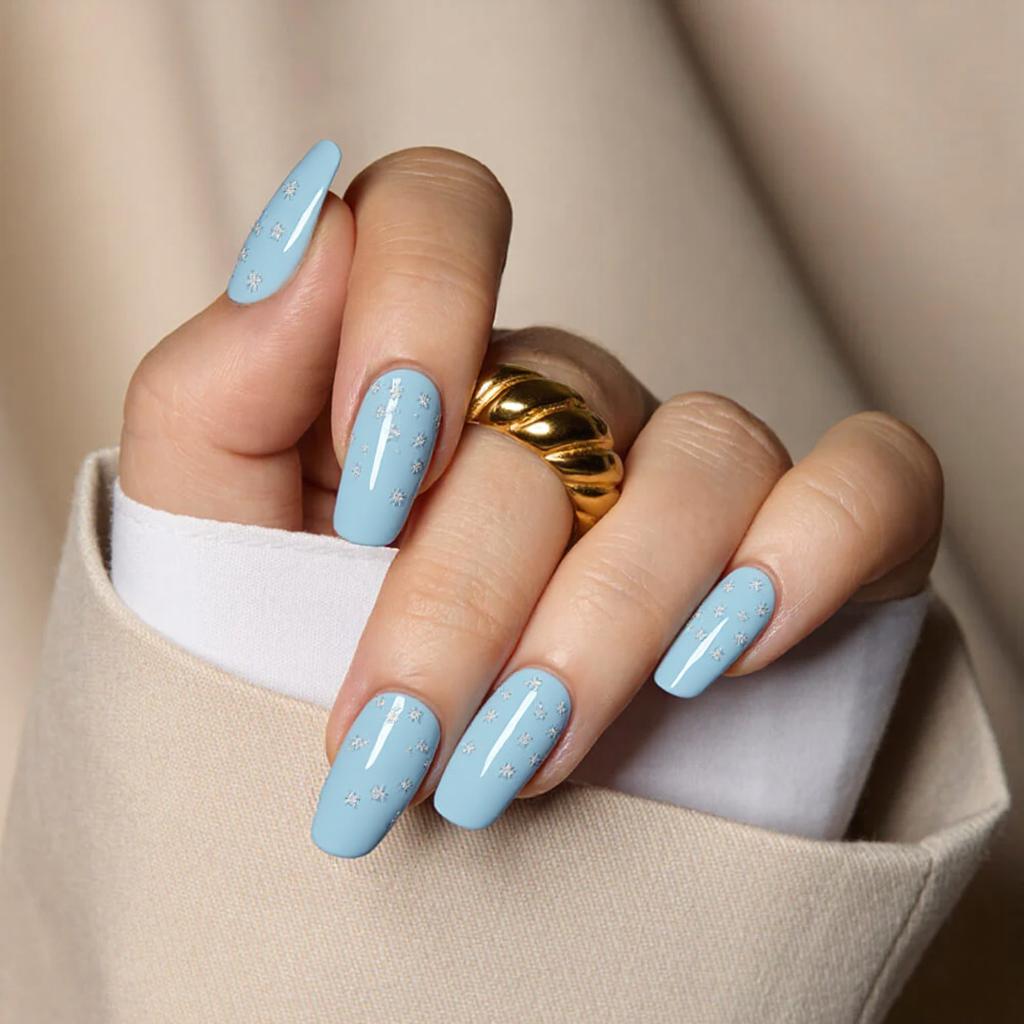 Medium square nails in a soft baby blue with a touch of white gradient at the tips and tiny snowflake stickers.