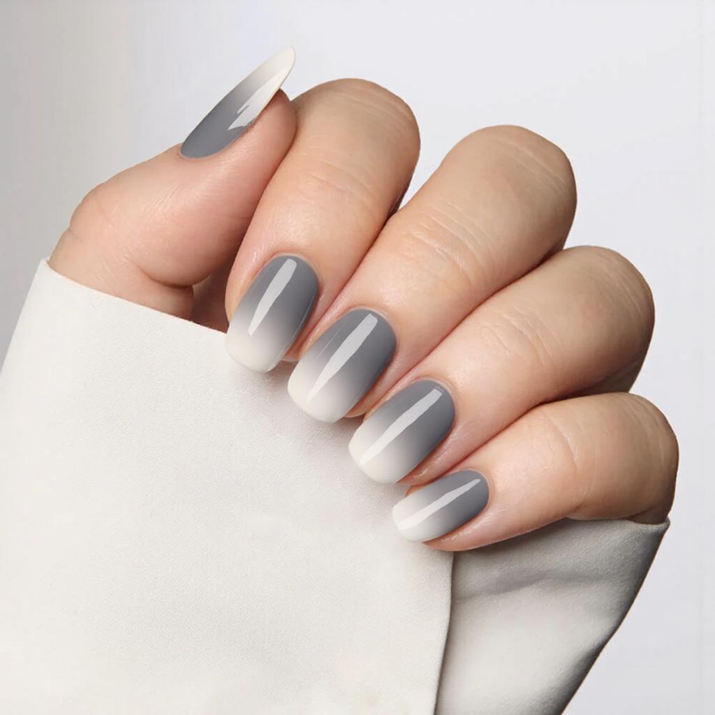 Medium almond nails in a gradient of gray hues, getting lighter toward the tips for a chic ombre look.