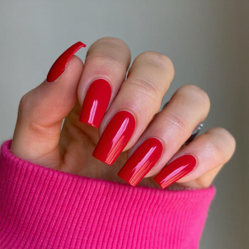 Long square nails in a bold cherry red, each topped with a high-shine topcoat for extra gloss.