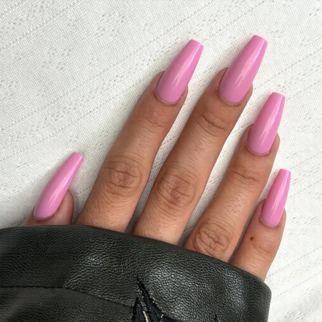 Long stiletto nails in a candy-pink ombre, transitioning from deeper pink at the cuticle to lighter at the tip.