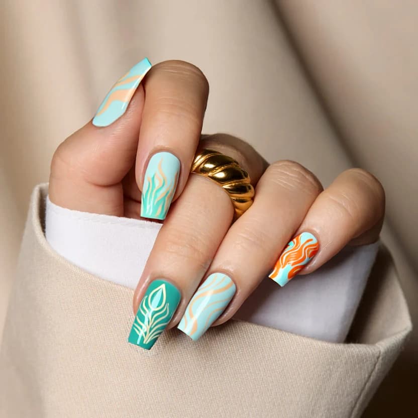 Nails featuring a soft, pastel color palette inspired by the elements of fire, water, earth, and air. The base color for all nails is a delicate powder blue, creating a serene backdrop. On the middle fingers, a subtle marbling effect in pastel orange and soft pink represents fire, with wispy, ethereal patterns to symbolize air. The index fingers showcase a gentle wave-inspired design in pastel teal to depict water, while the ring fingers are adorned with a muted green abstract floral pattern representing earth, incorporating simple leaf outlines in cream. The remaining nails remain pure powder blue for a balanced and harmonious look. A glossy finish enhances the overall elegance of this medium square nail design.