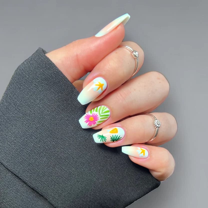 A bright and fun tropical nail design featuring soft pastel palm leaves and delicate hibiscus flowers, with subtle hints of pineapple motifs. The base color for all nails is a warm sandy beige, evoking a beachy feel. On the ring fingers, a minimalistic design showcases two small palm leaves and a singular hibiscus flower in soft pink, while the index fingers have a tiny, stylized pineapple in pastel yellow. The remaining nails are kept plain with the sandy beige base. A glossy finish enhances the overall fresh and vibrant aesthetic, perfect for a beach vacation.