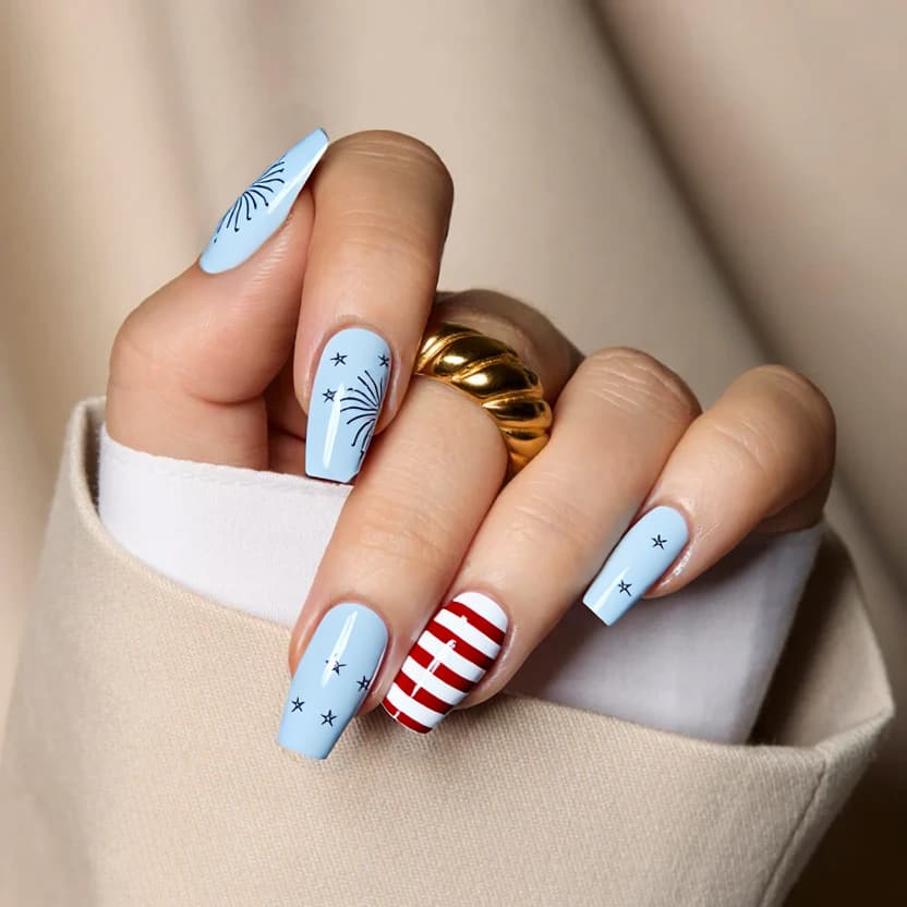 Nails featuring a soft pastel blue base color, providing a gentle and playful vibe perfect for a fun Fourth of July celebration. On the ring finger of each hand, a minimalist design showcases delicate white stars scattered across the nail, capturing the essence of fireworks in the night sky. The middle fingers are adorned with an elegant red and white striped pattern, inspired by the American flag but rendered in a subtle and understated manner. The rest of the nails remain a smooth pastel blue, ensuring the overall look is balanced and chic. A glossy finish enhances the cohesiveness of this festive yet refined design.