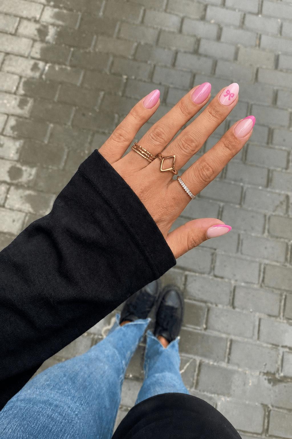 thumb: pink French tip pointer finger: aura effect with light and bright pink middle finger: pink French tip left index finger: bright pink bow facing away from the cuticle￼ with light pink background pinky: pink French tip Nail shape: almond. Nail length: medium. Only change the nails visible in the image to match this design. Keep the rest of the image — the hand, skin, background, lighting, and everything else — exactly the same.