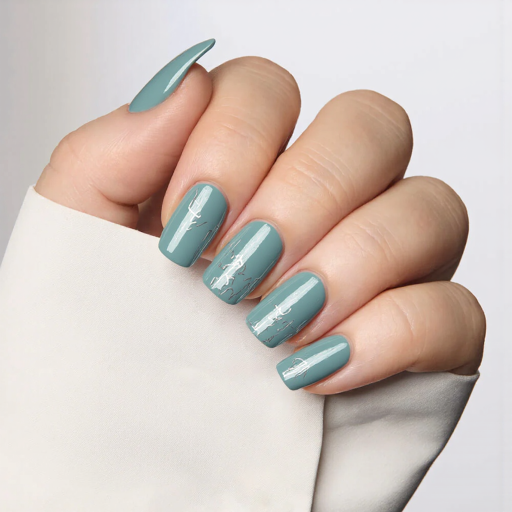 Medium almond nails in a soft iridescent teal with minimalist silver lines, offering a modern 2025 aesthetic.