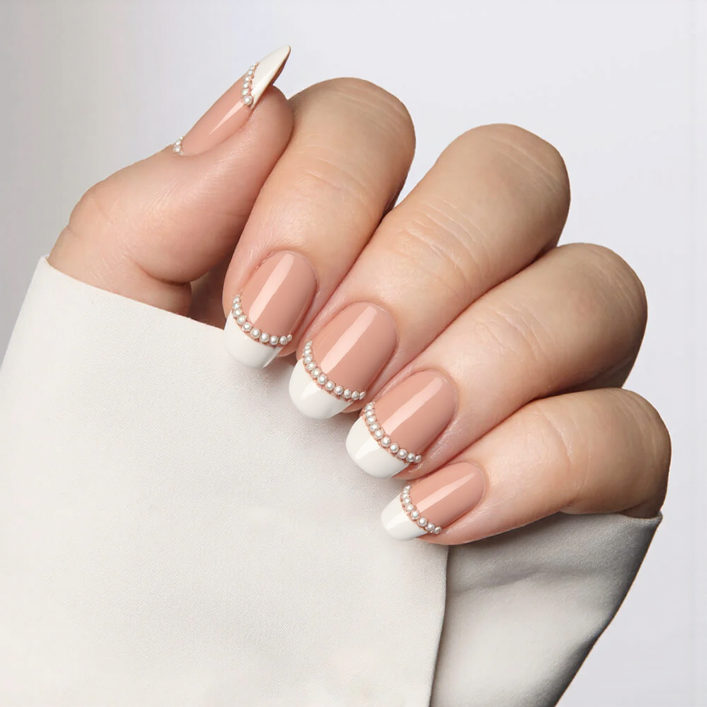 Medium almond nails with a classic French tip, each accent nail decorated with a tiny row of pearls along the line.