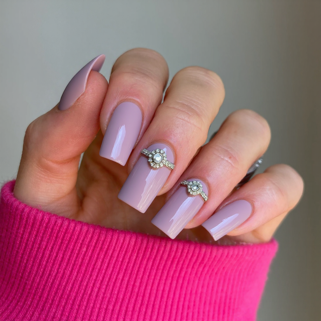 Long square nails in a soft mauve, each ring finger topped with a subtle crystal cluster for an engagement-worthy accent.