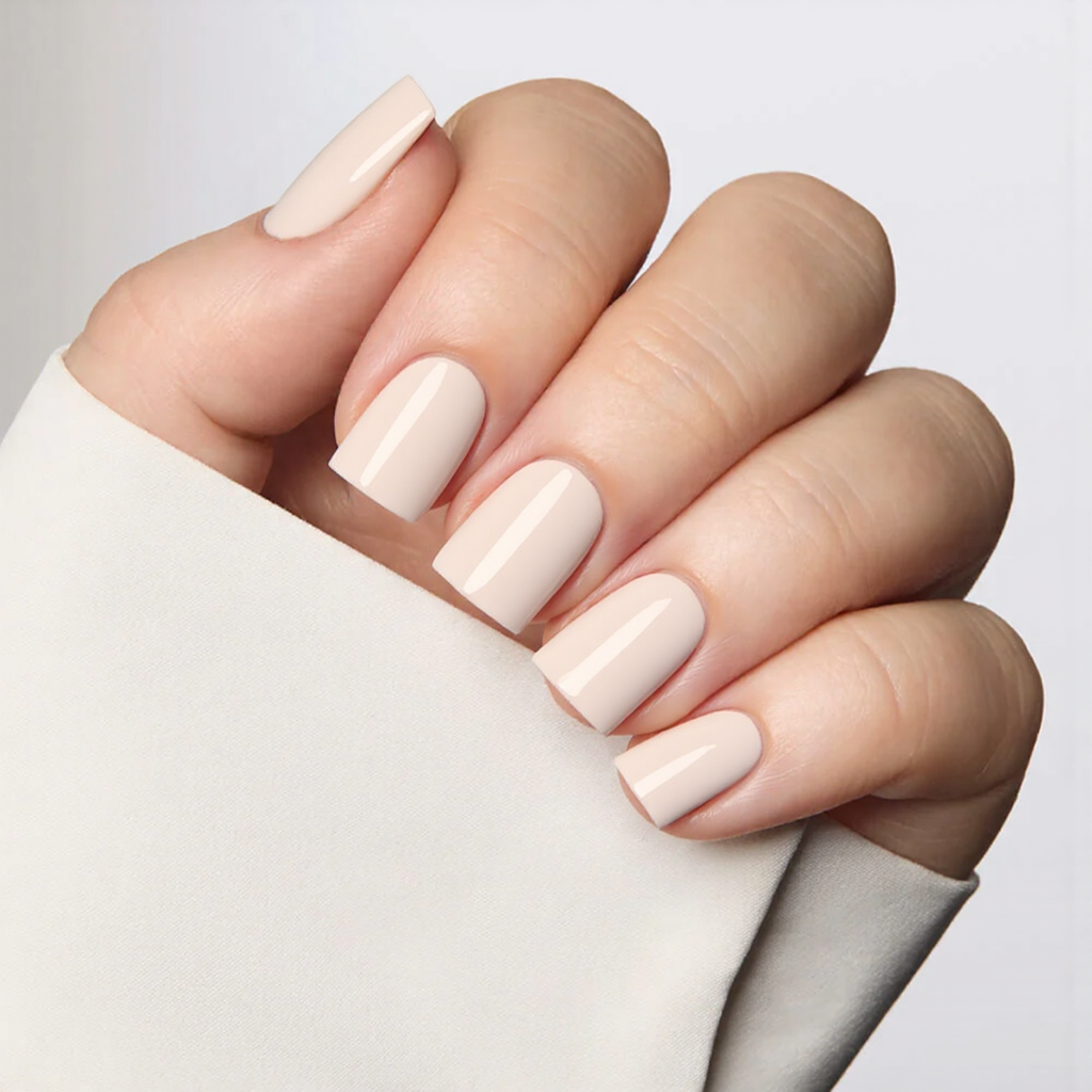 Short square nails in a milky-white polish, giving them a simple yet polished appearance.