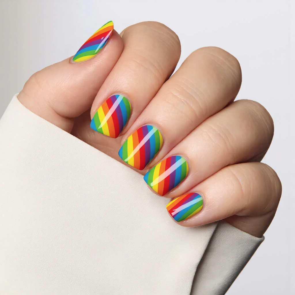 Short square nails with a retro rainbow stripe nail art, evoking that 70s vibe.