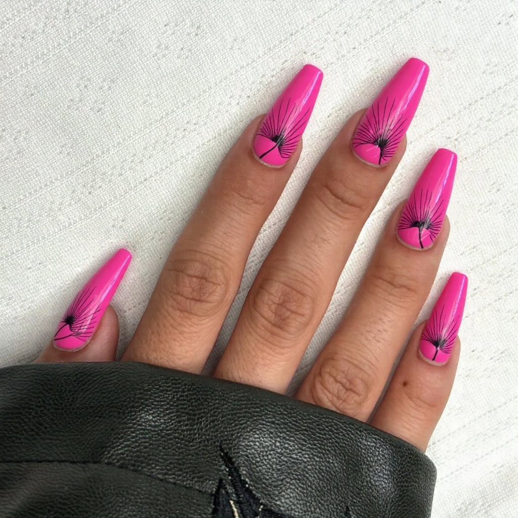 Long stiletto nails in a vibrant flamingo pink with feather accents for a tropical getaway vibe.