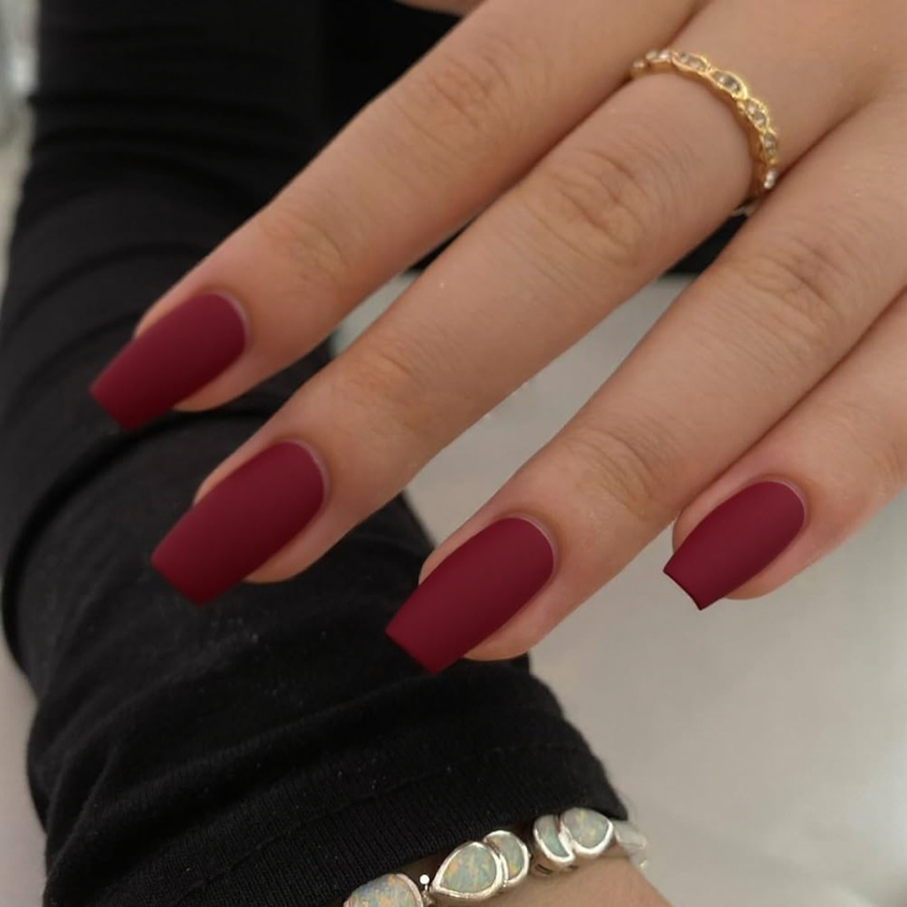 Short stiletto nails in a bold crimson red with a matte finish, great for January celebrations.