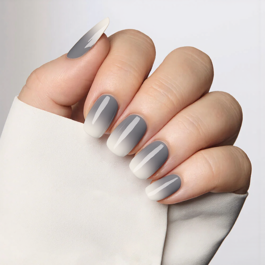 Medium almond nails in a gradient of gray hues, getting lighter toward the tips for a chic ombre look.