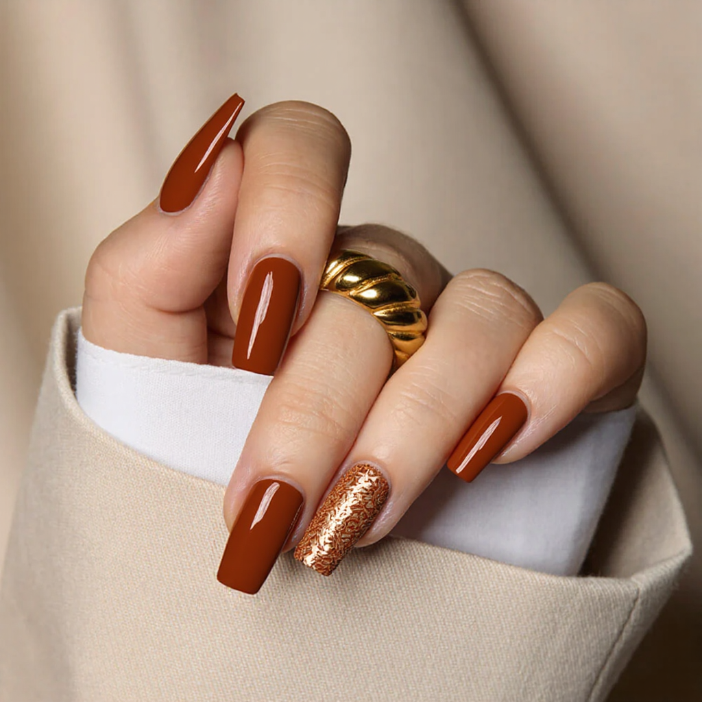 Looking for medium square nails with a burnt orange base and a subtle leaf pattern on the ring finger.