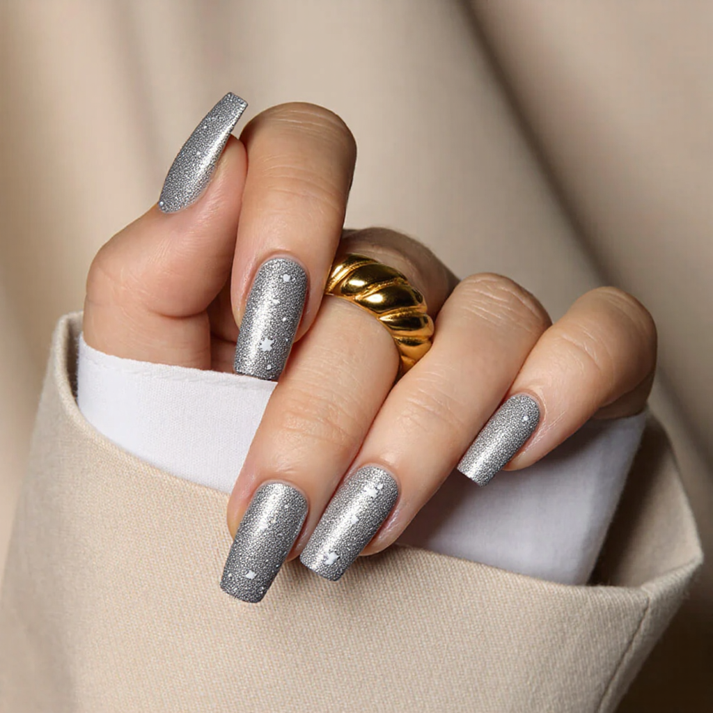 Medium square nails in a shimmering silver with delicate snowflake designs for a winter holiday vibe.