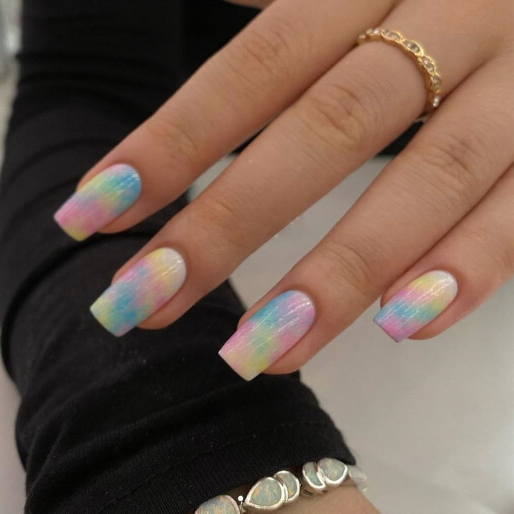 Short stiletto nails with an artistic watercolor splash nail art across each nail for a soft, dreamy look.