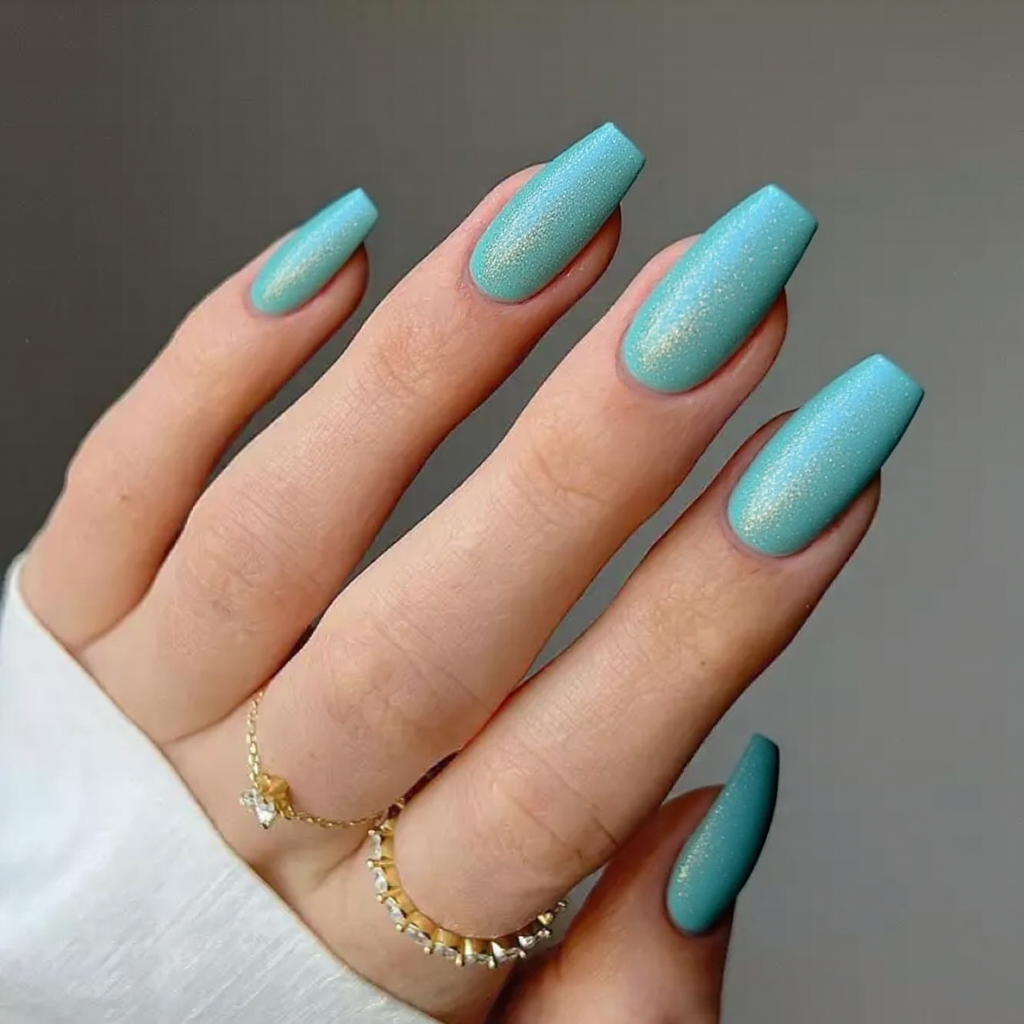 Medium stiletto nails in a glossy turquoise with subtle glitter for a glamorous poolside appearance.