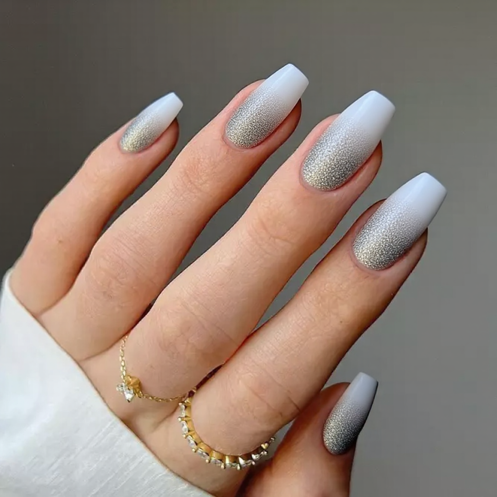 Medium stiletto nails in an ombre that transitions from icy white at the tips to a sparkling silver at the base.