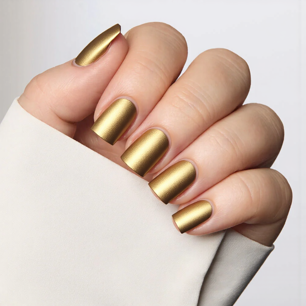 Short square nails in a metallic gold with a matte finish, ideal for a chic New Year's Eve look.