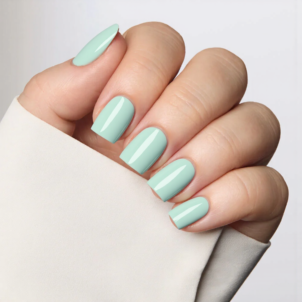 Short square nails in a pastel mint, adding a thin white stripe across the tips for a fresh look.