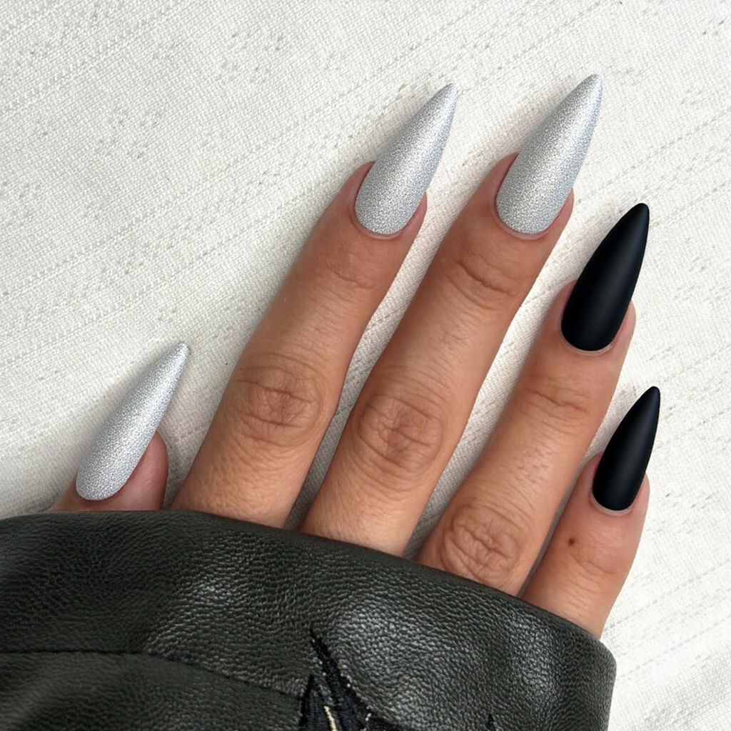 Long stiletto nails in a glittery white with a matte black accent nail for a bold winter statement.