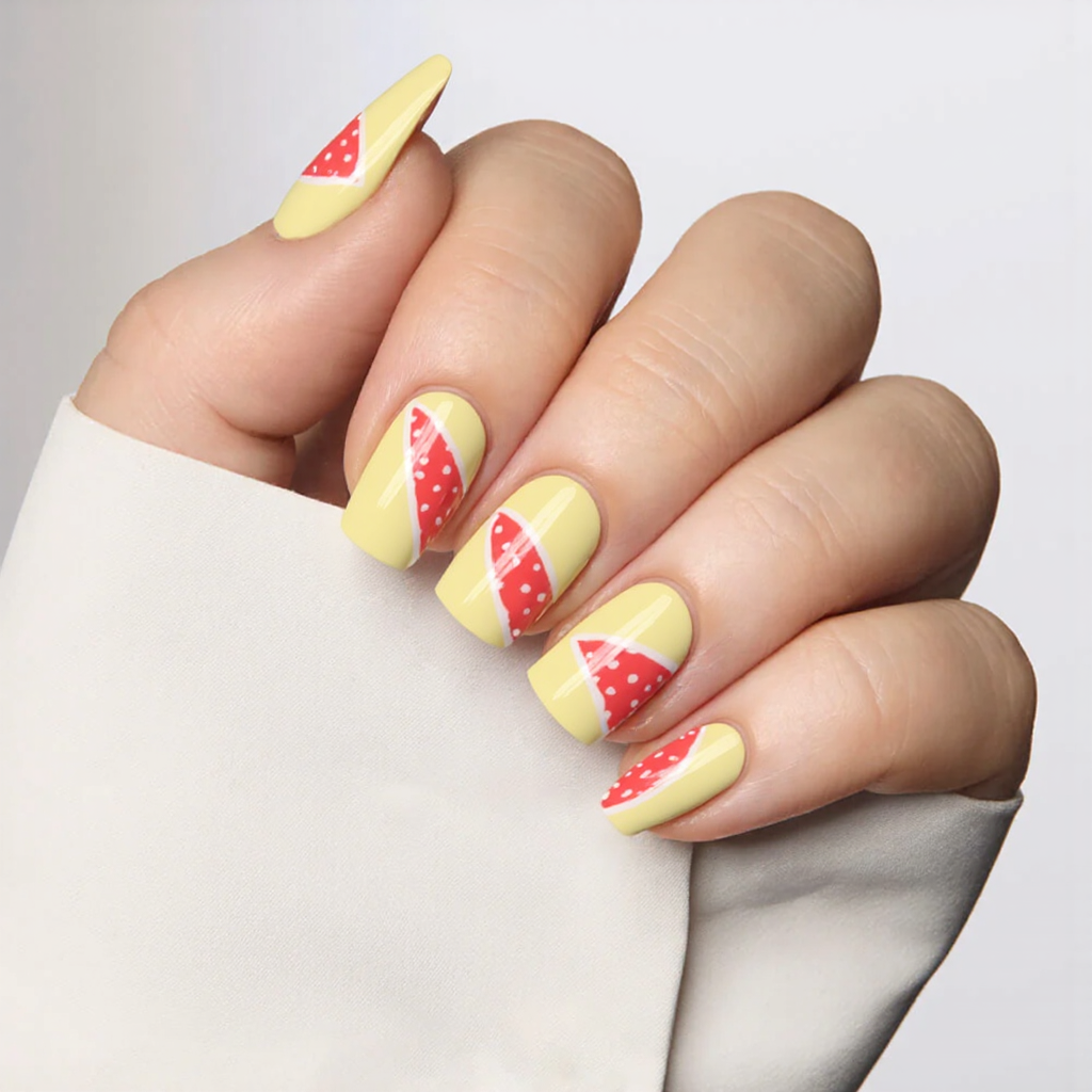 Medium almond nails in a pale yellow with tiny watermelon slices on one or two accent nails.