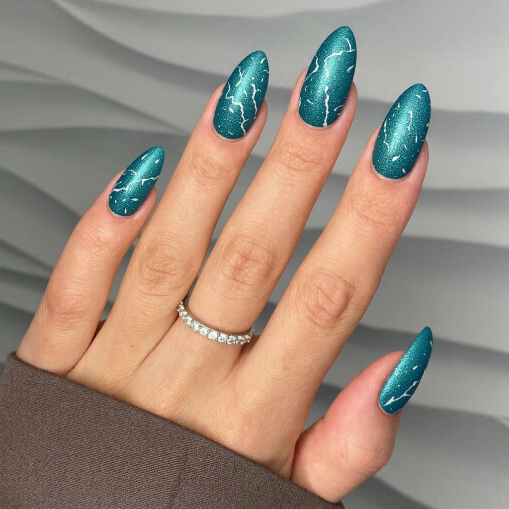 Long almond nails in a shimmering teal that reminds me of frozen lakes, with delicate white swirl details.