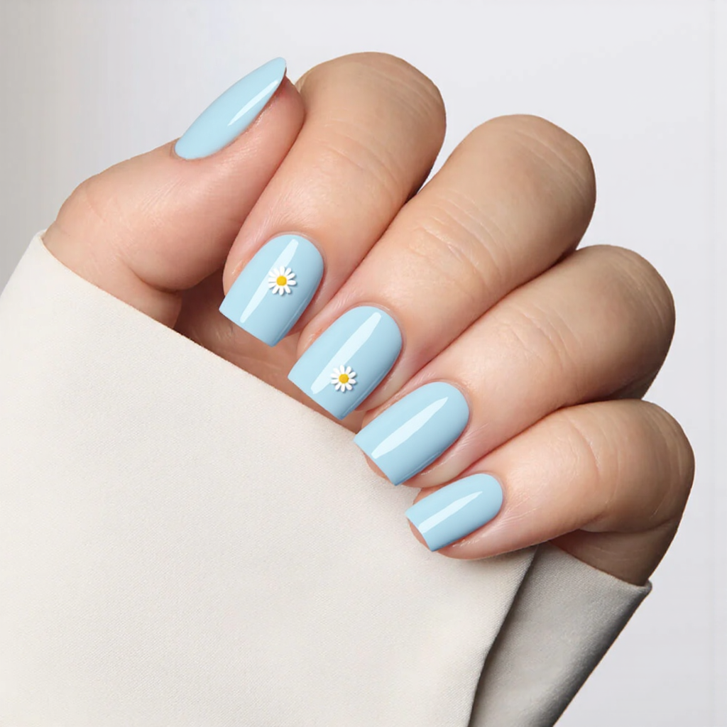 Short square nails in pastel sky blue, each topped with a small daisy sticker for a fresh look.