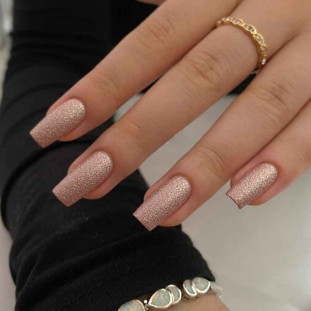 Short stiletto nails in a romantic rose gold glitter, focusing extra sparkle on the ring finger to show off my new ring.