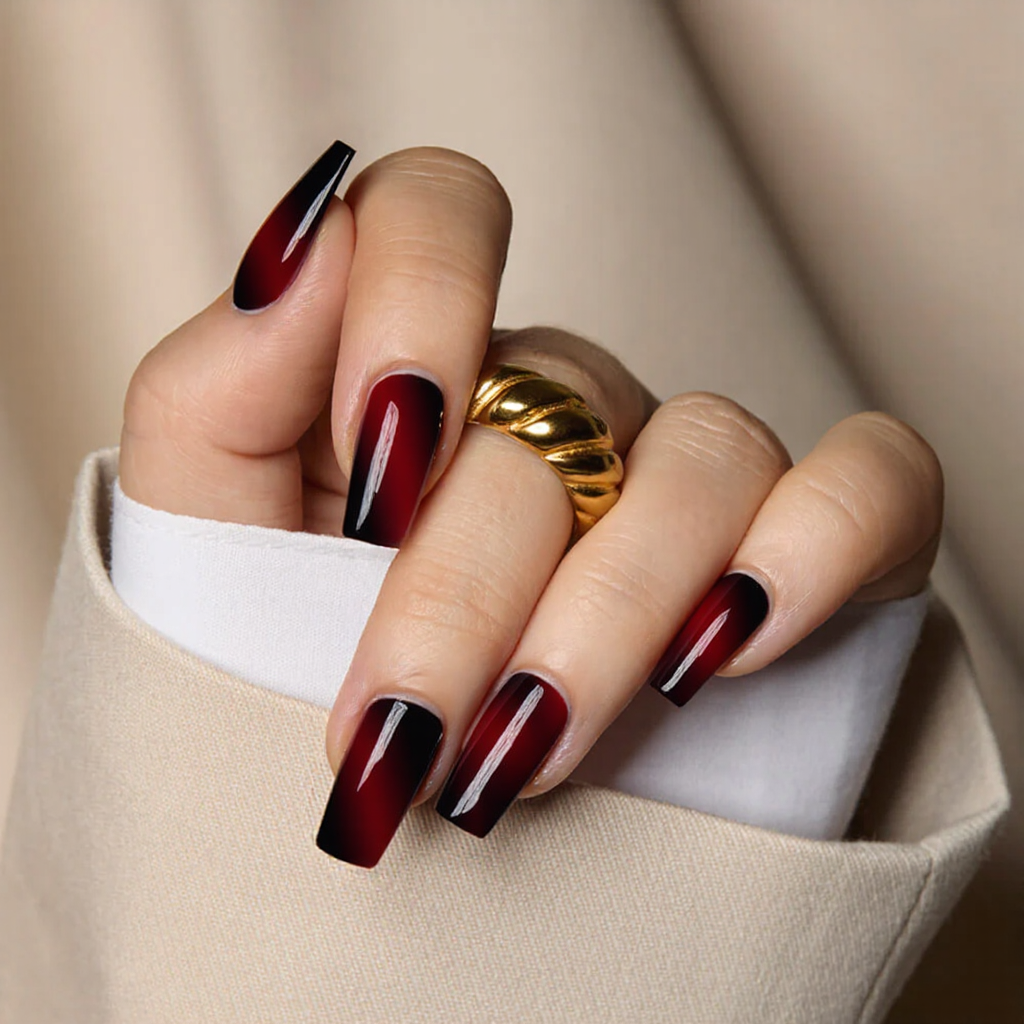 Medium square nails in a dark red ombre, fading to black at the tips for a dramatic look.