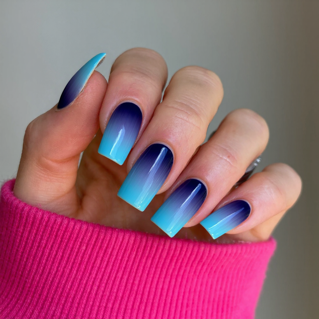 Long square nails in a striking ombre from navy blue to sky blue, creating a beautiful gradient effect.